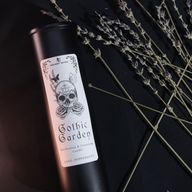 Detailný záber etikety sviečky Gothic Garden so lebkou, ružami a motýľmi.