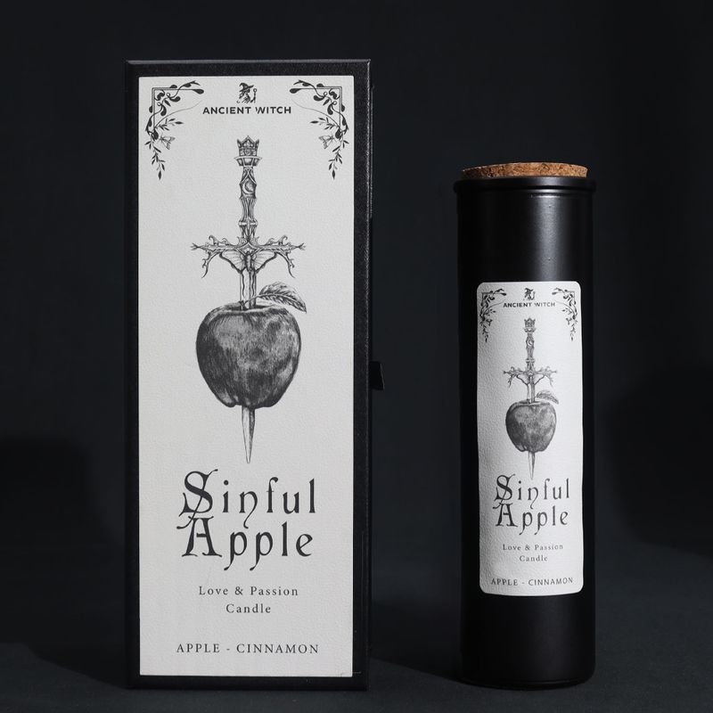 Rituálna sviečka Sinful Apple a darčeková krabička s jablkom prepichnutým athame na čiernom pozadí