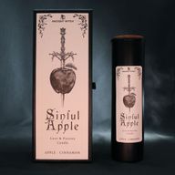 Rituálna sviečka Sinful Apple, vystavená so svojím ilustrovaným obalom.