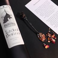 Záber zblízka na etiketu sviečky Locked Desires s netopierom vo vnútri klietky.